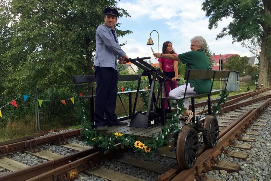 Besucher des Eisenbahnmuseums Kötzschau fahren mit einer Draisine