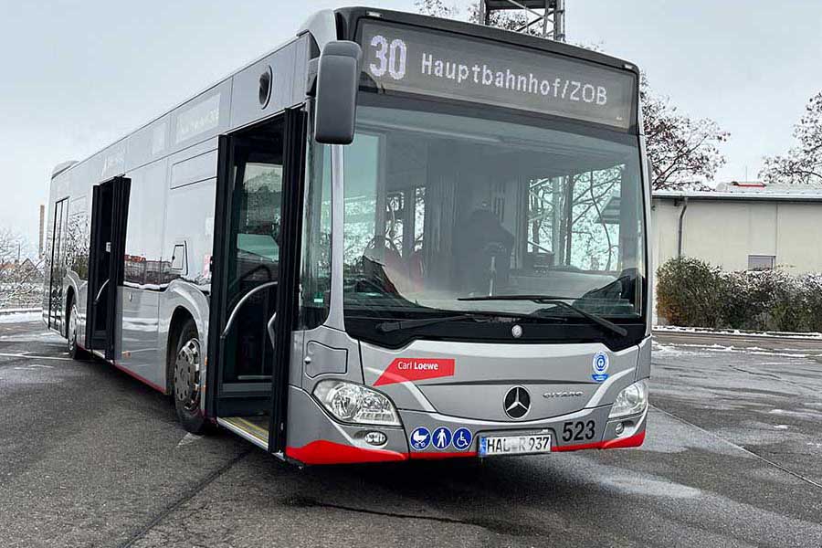 Moderner Stadtbus der Linie 30 mit geöffneter Tür und Zielanzeige '30 Hauptbahnhof/ZOB' auf einem Parkplatz