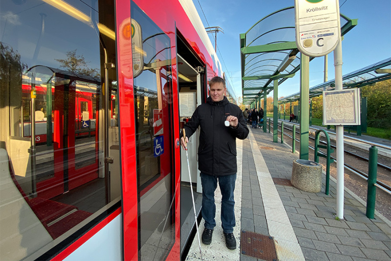 Blinder Fahrgast zeigt den BIOS Sender in die Kamera.