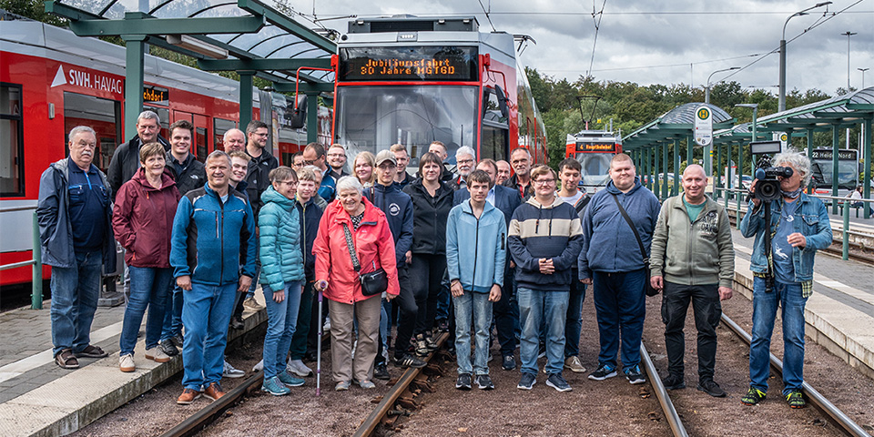 Die Teilnehmerinnen und Teilnehmer der Jubiläumsfahrt vor einer MGT6 Bahn.