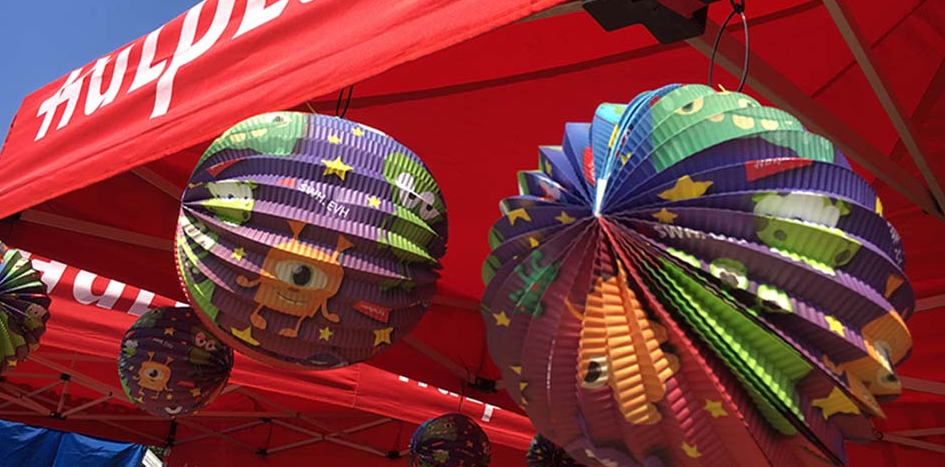 Bunte Lampions hängen an einem Zelt. 