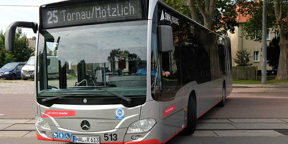 Moderner Mercedes-Stadtbus der Linie 25 mit Zielanzeige 'Tornau/Mötzlich' steht auf einer Straße vor Bäumen und Häusern.