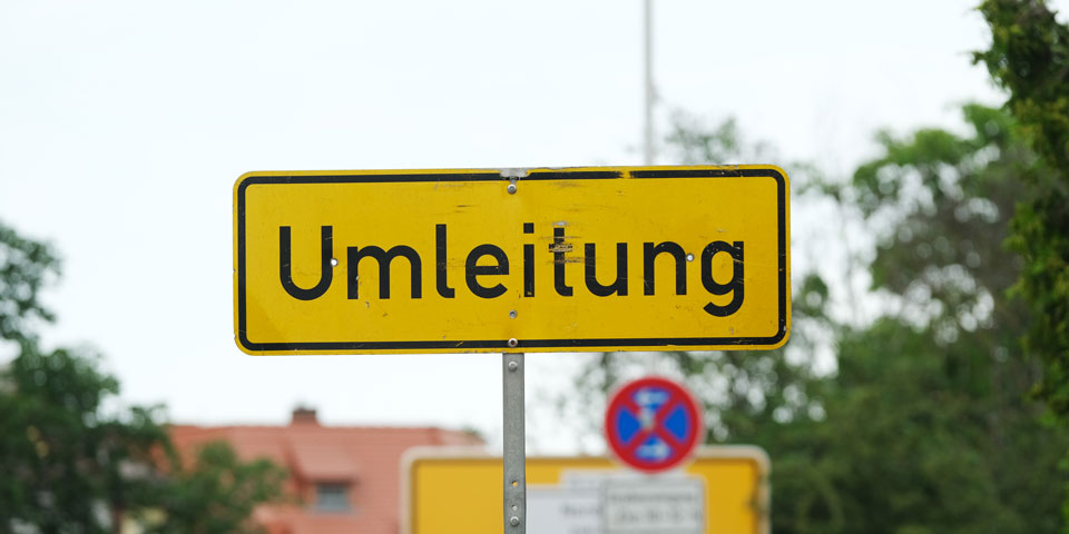 gelbes Straßenschild mit der schwarzen Aufschrift Umleitung 