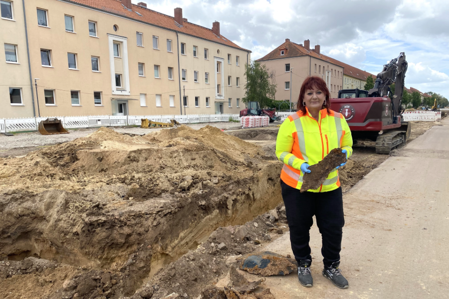 Die Projektleiterin hält einen Bombensplitter in den Händen.