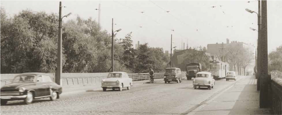 Ein schwarz-weiß-Foto. Gemacht auf der Elisabethbrücke. Autos und eine Straßenbahn fahren in beide Richtungen. Auch ein Fahrradfahrer ist zu erkennen. Auf beiden Seiten gibt es einen Fußgängerweg.