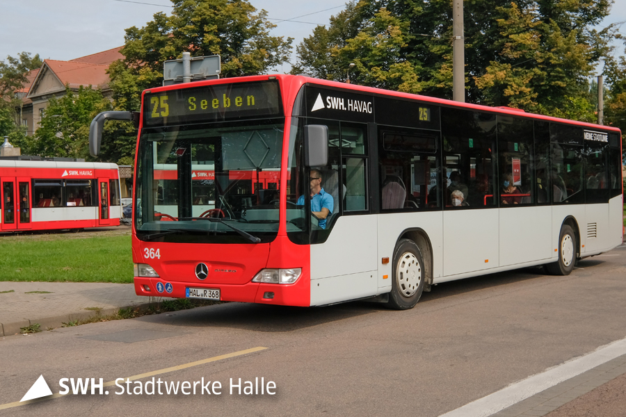 Ein roter Bus mit der Nummer 25 fährt durch ein Stadtgebiet.