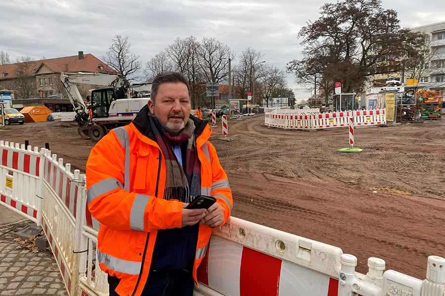 Mitarbeiter steht vor Baustelle.