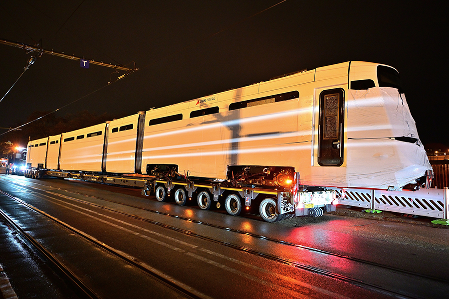 Die TINA-Straßenbahn, die auf einem Tieflader ankommt, ist noch ganz in Folie gehüllt.