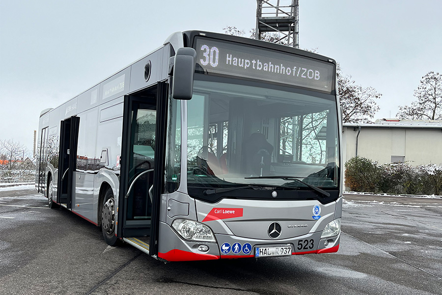 Eine Aufnahme eines silbernen Busses der HAVAG auf einem Platz. Um den Bus liegt ein bisschen Schnee. Der Bus hat die Zielaufschrift "30 Hauptbahnhof/ZOB".