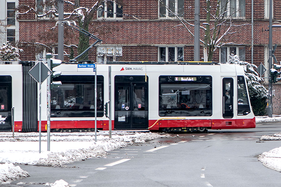 TINA Straßenbahn fährt in winterlicher Umgebung im Stadtgebiet