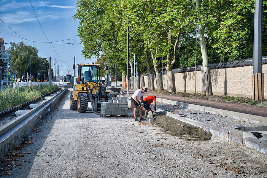 Zwei Bauarbeiter bauen Straßenborde.