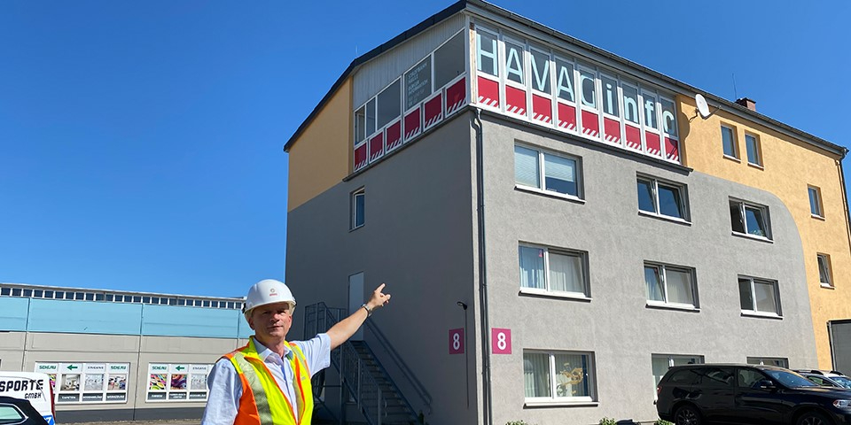 Mitarbeiter zeigt auf HAVAG Baubüro.