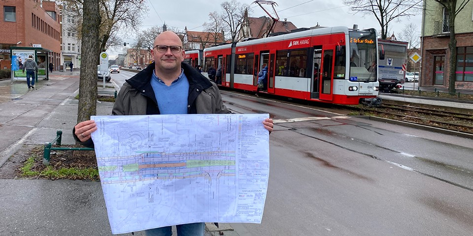 Mitarbeiter hält Bauplan.