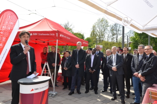 Matthias Lux, Vorsitzender der Geschäftsführung der Stadtwerke Halle GmbH, hat ein Mikro in der Hand und spricht zu den Gästen. Im Hintergrund ist ein rotes Stadtwerke-Zelt.