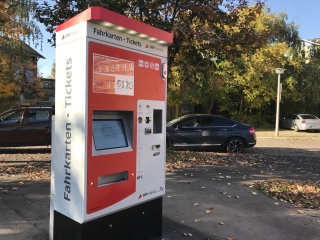 Im Bild ist der erste neue Fahrkartenautomat an der Haltestelle "betriebshof Freiimfelder Straße" zu sehen. Optisch ist er auf den ersten Blick nicht von seinem Vorgänger zu unterscheiden. Der graue Automat weckt durch seine rote Beklebung Aufmerksamkeit.