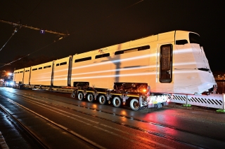 Die neue TINA-Bahn wird mit einem großen Tieflader angefahren.