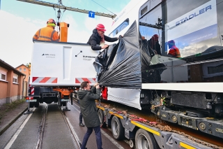 Die TINA ist noch in Folie gehüllt. HAVAG-Vorstand Vinzenz Schwarz entfernt sie feierlich zur Begrüßung der neuen Bahn.