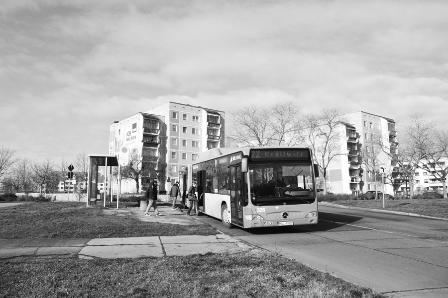 Ein Schwarz-Weiß-Bild: Ein Bus an einer Haltestelle.