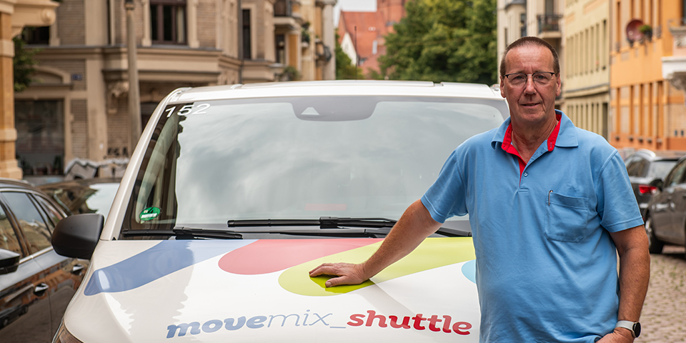 Ein Fahrer steht an unserem movemix_shuttle im Paulusviertel.