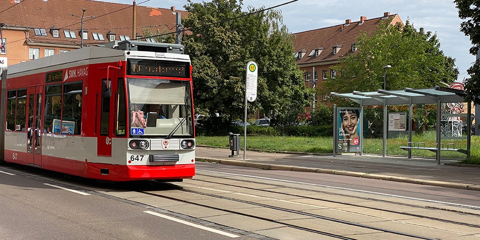 Straßenbahn vor Haltestelle.