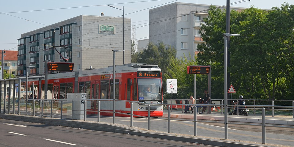 Straßenbahn an Haltestelle.